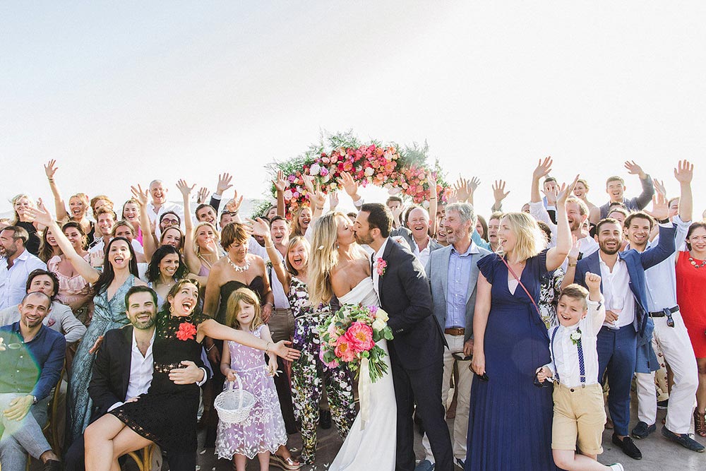 colorful floral hoop wedding backdrop with modern off-the-shoulder bridal gown and black groom suit