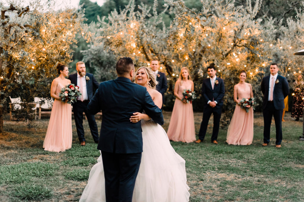 strapless ruffled wedding dress with tulle skirt and custom navy groom suit first dance